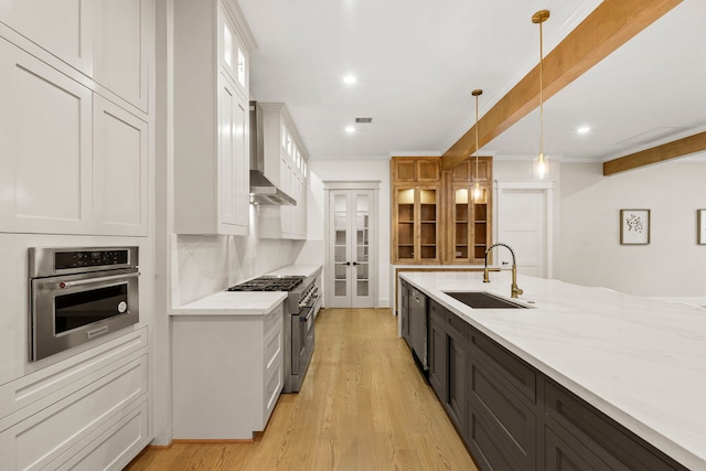 6001 Norhill Blvd, Houston, TX 77009 - kitchen featuring stainless steel appliances, a sink, wall chimney exhaust hood, white cabinetry, and recessed lighting