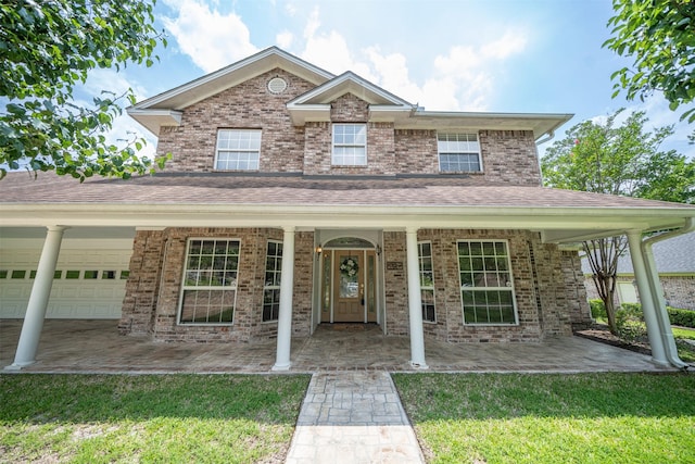 918 Dogwood Ridge Dr, Diboll, TX 75941 - traditional home featuring an attached garage, a front lawn, a shingled roof, a porch, and brick siding