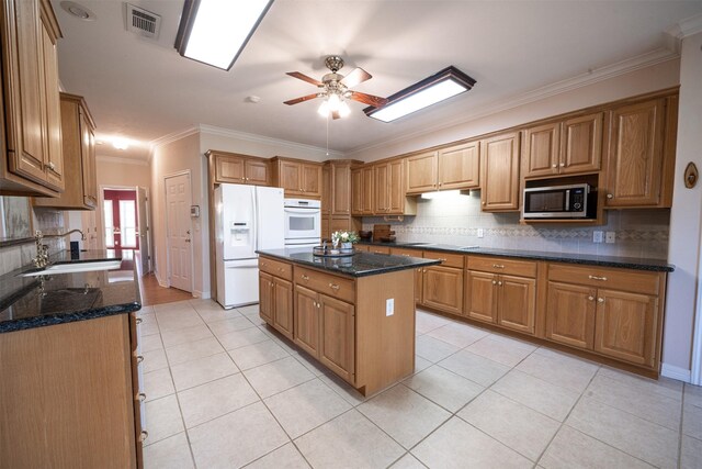 918 Dogwood Ridge Dr, Diboll, TX 75941 - kitchen with white fridge with ice dispenser, stainless steel microwave, ceiling fan, a sink, and light tile patterned floors