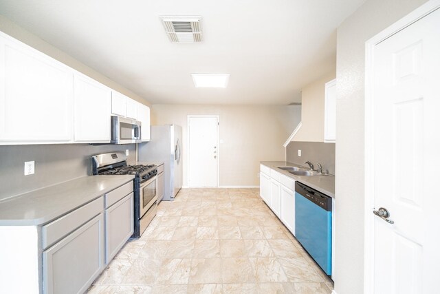 22802 Sherioaks Ln, Spring, TX 77389 - kitchen with stainless steel appliances, a sink, light countertops, and white cabinets