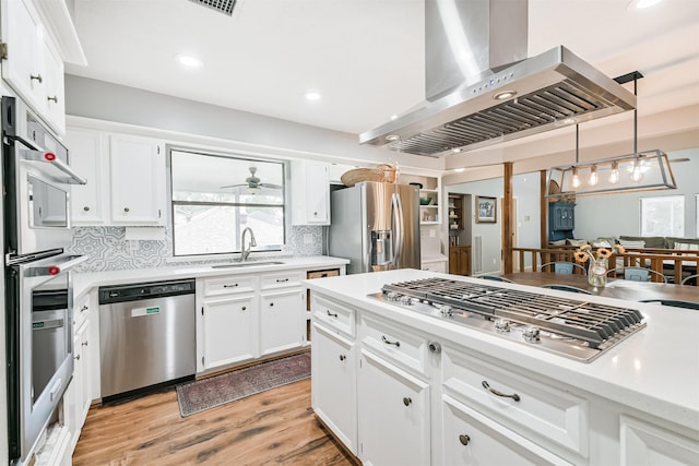 20002 18th Fairway Dr, Humble, TX 77346 - kitchen with wall chimney range hood, appliances with stainless steel finishes, a sink, ceiling fan, and light countertops