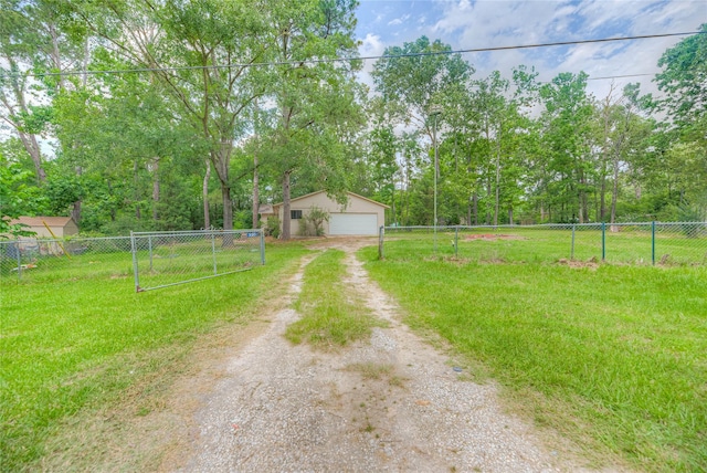 330 Oak Tree Dr, Point Blank, TX 77364 - view of yard featuring driveway, a detached garage, an outdoor structure, and view of wooded area