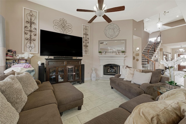 16946 Creek Mountain Dr, Houston, TX 77084 - tiled living area featuring stairway, ceiling fan, a fireplace with raised hearth, and baseboards