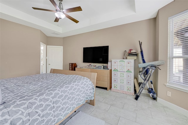 16946 Creek Mountain Dr, Houston, TX 77084 - bedroom with a raised ceiling, light tile patterned flooring, a ceiling fan, and baseboards