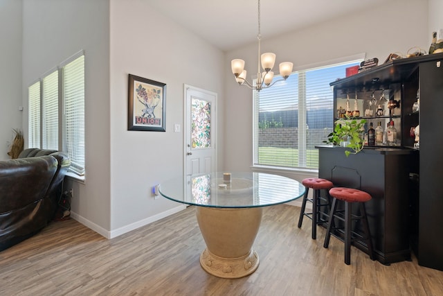25718 Balsamwood Dr, Tomball, TX 77375 - dining room with a dry bar, light wood finished floors, and a chandelier