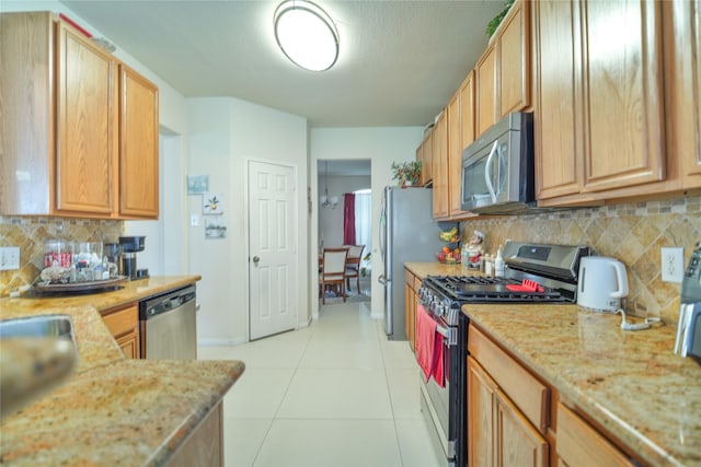13614 Birch Canyon Ct, Houston, TX 77041 - kitchen with appliances with stainless steel finishes, light tile patterned floors, backsplash, light stone countertops, and baseboards