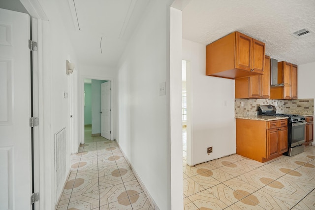 11707 N Nottingham Cir, Houston, TX 77071 - kitchen with stainless steel range with gas cooktop, wall chimney range hood, light tile patterned flooring, tasteful backsplash, and brown cabinetry