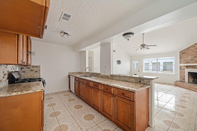 11707 N Nottingham Cir, Houston, TX 77071 - kitchen featuring brown cabinetry, tasteful backsplash, light stone countertops, a sink, and lofted ceiling