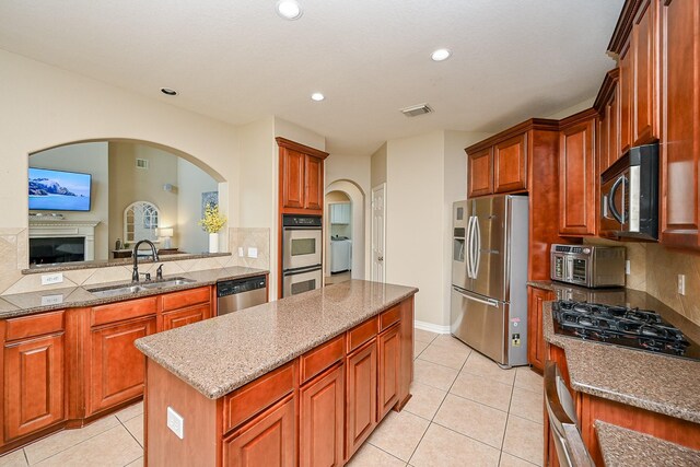 20803 Twisted Leaf Dr, Cypress, TX 77433 - kitchen featuring appliances with stainless steel finishes, a kitchen island, light tile patterned floors, tasteful backsplash, and recessed lighting