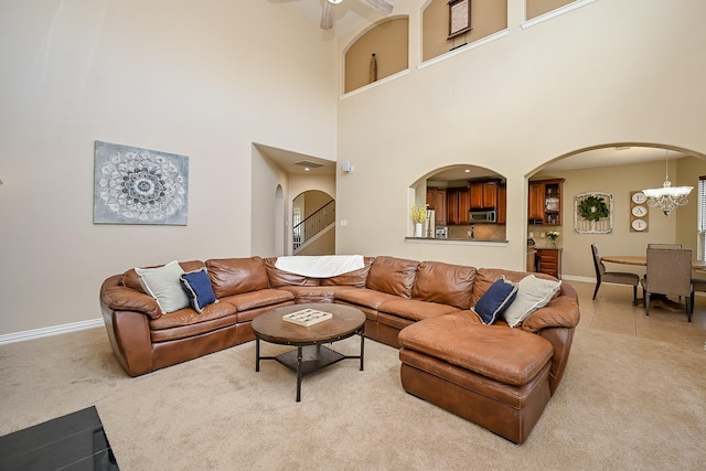 20803 Twisted Leaf Dr, Cypress, TX 77433 - living area with light carpet, arched walkways, a ceiling fan, a chandelier, and a towering ceiling