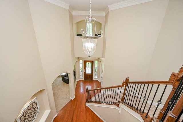20803 Twisted Leaf Dr, Cypress, TX 77433 - entryway featuring a chandelier, wood finished floors, a towering ceiling, stairs, and crown molding