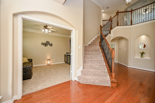20803 Twisted Leaf Dr, Cypress, TX 77433 - staircase featuring arched walkways, wood finished floors, ceiling fan, and crown molding