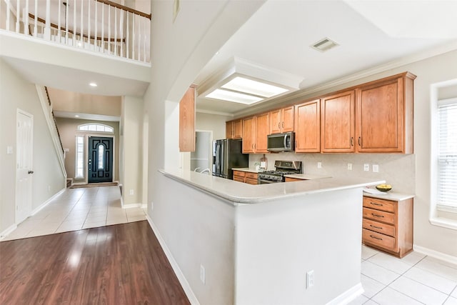 2231 Water Way, Seabrook, TX 77586 - kitchen featuring stainless steel appliances, light countertops, light tile patterned floors, decorative backsplash, and a peninsula