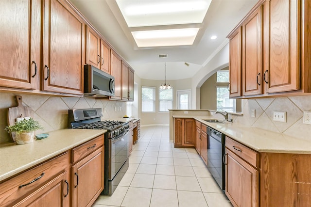 2231 Water Way, Seabrook, TX 77586 - kitchen featuring stainless steel appliances, a chandelier, light tile patterned flooring, decorative backsplash, and brown cabinets