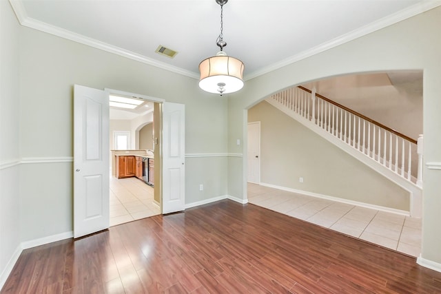 2231 Water Way, Seabrook, TX 77586 - spare room featuring arched walkways, ornamental molding, wood finished floors, and stairway