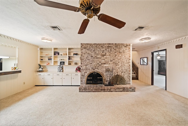 2709 Cherry Ln, Pasadena, TX 77502 - unfurnished living room featuring a ceiling fan, a textured ceiling, light carpet, a brick fireplace, and stairway