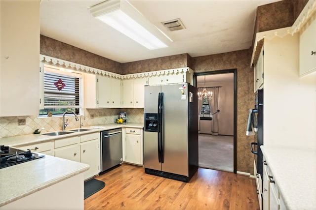 2709 Cherry Ln, Pasadena, TX 77502 - kitchen featuring stainless steel appliances, light wood finished floors, light countertops, a sink, and tasteful backsplash