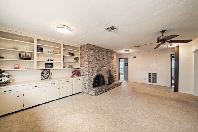 2709 Cherry Ln, Pasadena, TX 77502 - unfurnished living room featuring ceiling fan, healthy amount of natural light, a fireplace, a textured ceiling, and light colored carpet