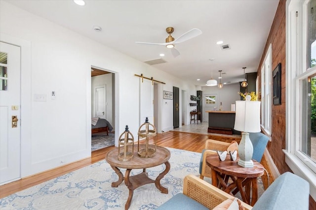 1604 S Austin St, Brenham, TX 77833 - living room featuring a barn door, light wood-type flooring, recessed lighting, a ceiling fan, and baseboards