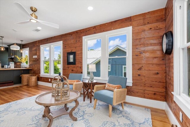 1604 S Austin St, Brenham, TX 77833 - living area with wood finished floors, baseboards, a ceiling fan, and wooden walls