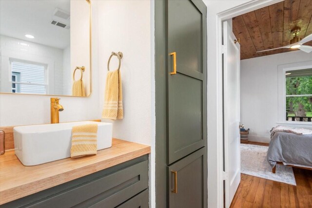 1604 S Austin St, Brenham, TX 77833 - bathroom with wood finished floors, wooden ceiling, vanity, connected bathroom, and recessed lighting