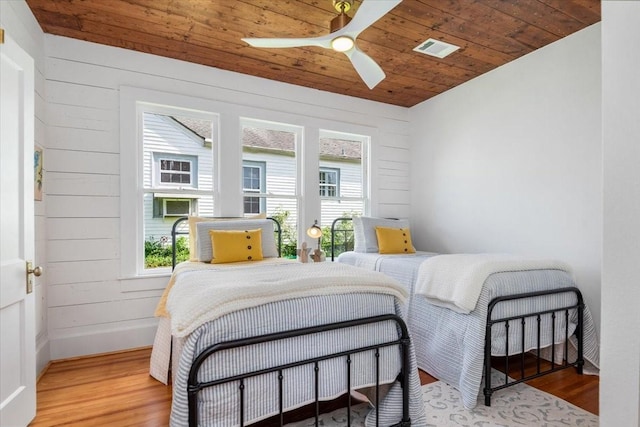 1604 S Austin St, Brenham, TX 77833 - bedroom with wood finished floors, wooden ceiling, baseboards, wooden walls, and a ceiling fan