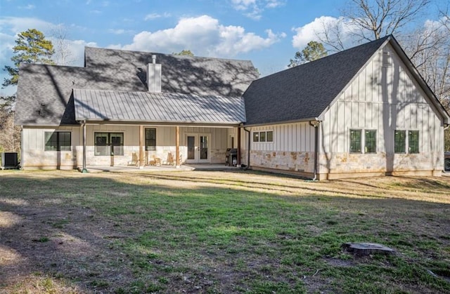 148 Wagon Pass Dr, Huntsville, TX 77340 - back of property featuring french doors, board and batten siding, a lawn, a chimney, and central AC