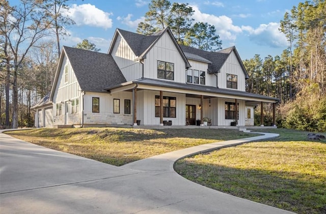 148 Wagon Pass Dr, Huntsville, TX 77340 - modern farmhouse with a porch, board and batten siding, a shingled roof, a front lawn, and a garage