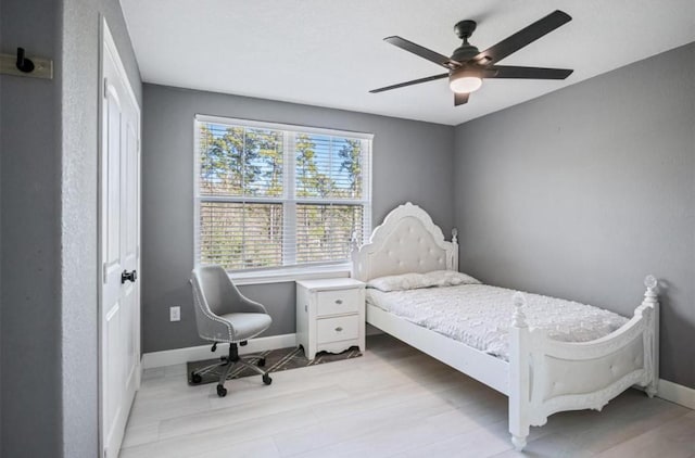 148 Wagon Pass Dr, Huntsville, TX 77340 - bedroom featuring baseboards, ceiling fan, and light wood-style floors