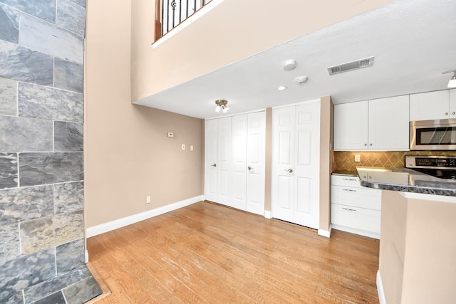 2300 Old Spanish Trl Unit 2078, Houston, TX 77054 - kitchen with stainless steel microwave, light wood-style flooring, white cabinetry, range, and baseboards