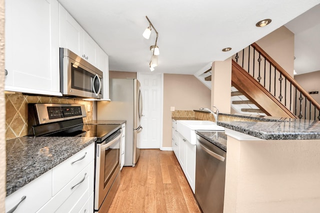 2300 Old Spanish Trl Unit 2078, Houston, TX 77054 - kitchen with stainless steel appliances, a sink, backsplash, light wood-style flooring, and white cabinets