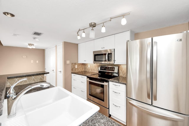 2300 Old Spanish Trl Unit 2078, Houston, TX 77054 - kitchen featuring appliances with stainless steel finishes, a sink, tasteful backsplash, white cabinets, and dark countertops