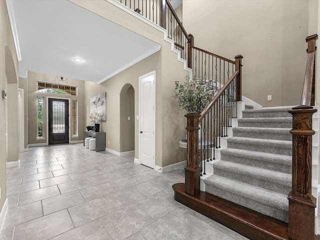 20722 Lavone Dr, Porter, TX 77365 - foyer featuring arched walkways, crown molding, stairway, and baseboards