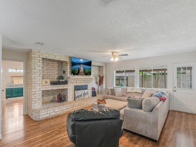 16414 Cavendish Dr, Houston, TX 77059 - living area with a textured ceiling, ceiling fan, wood finished floors, and a fireplace