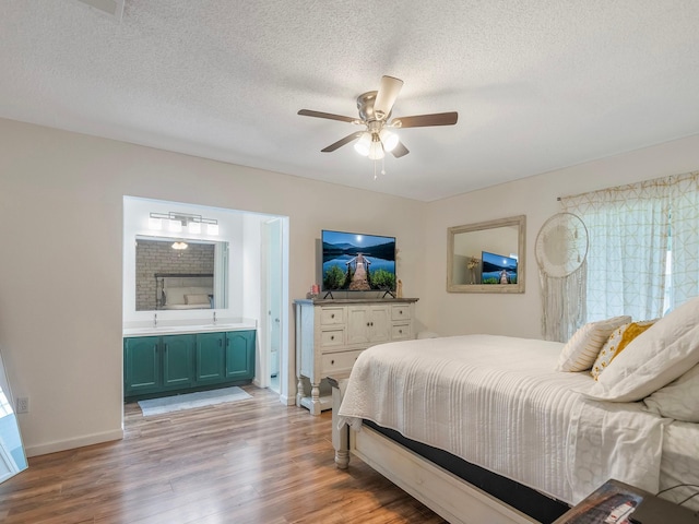 16414 Cavendish Dr, Houston, TX 77059 - bedroom with light wood finished floors, baseboards, connected bathroom, a textured ceiling, and a sink