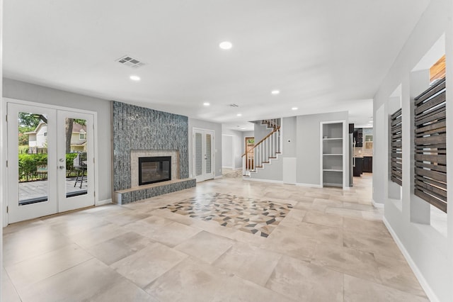 10714 Deerwood Rd, Houston, TX 77042 - unfurnished living room featuring french doors, recessed lighting, stairway, and a large fireplace