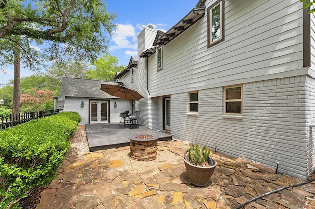 10714 Deerwood Rd, Houston, TX 77042 - back of property featuring french doors, a fire pit, a chimney, a patio area, and a wooden deck