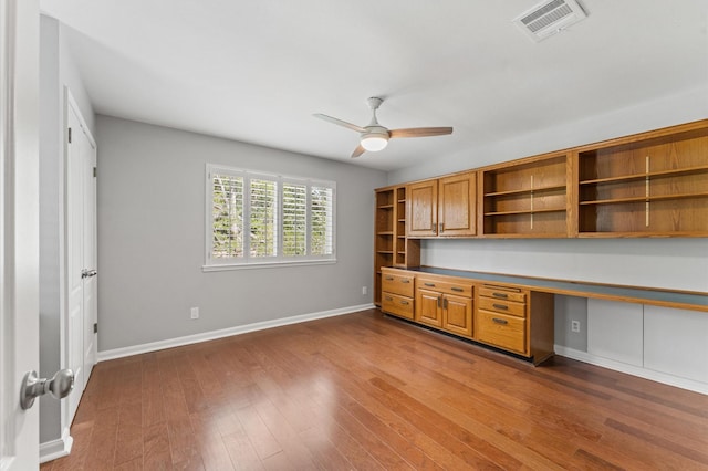 10714 Deerwood Rd, Houston, TX 77042 - unfurnished office with built in study area, a ceiling fan, and dark wood-style flooring