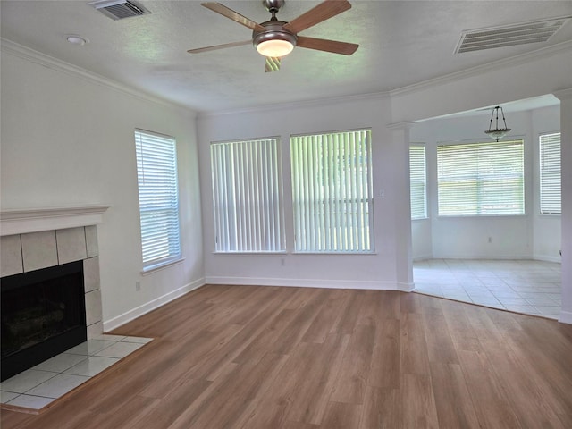 3307 Twelve Oaks Ln, Missouri City, TX 77459 - unfurnished living room with light wood-style flooring, a ceiling fan, crown molding, and a tiled fireplace