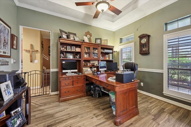 4810 Majestic Dr, Baytown, TX 77523 - home office featuring light wood-style flooring, ceiling fan, ornamental molding, and a tray ceiling