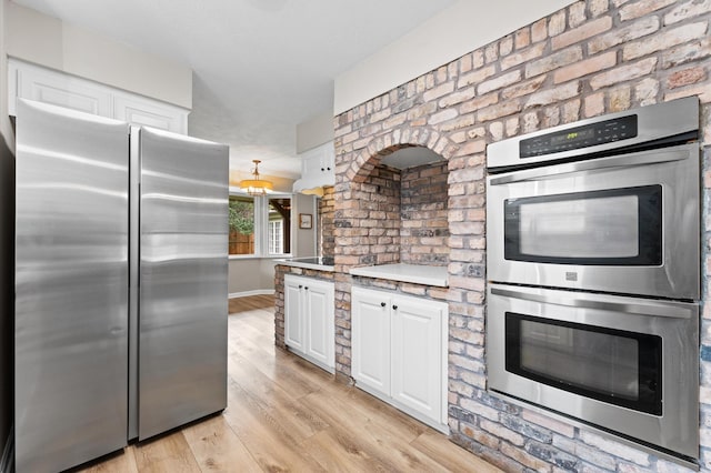 9407 Brooding Oak Cir, Houston, TX 77096 - kitchen with stainless steel appliances, white cabinetry, light wood-style flooring, and light countertops