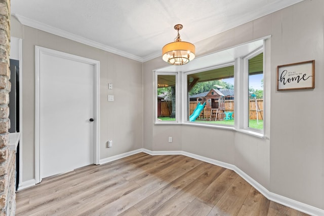 9407 Brooding Oak Cir, Houston, TX 77096 - unfurnished dining area with crown molding, light wood-style floors, a chandelier, and baseboards