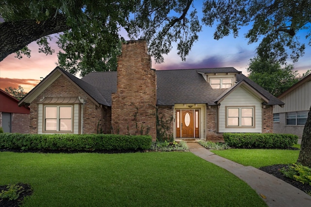 9407 Brooding Oak Cir, Houston, TX 77096 - view of front of home featuring a lawn, brick siding, a chimney, and roof with shingles
