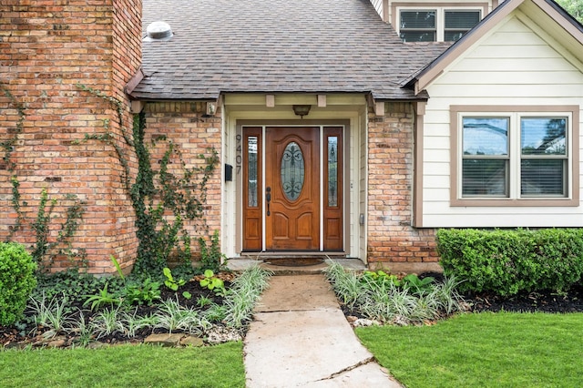 9407 Brooding Oak Cir, Houston, TX 77096 - entrance to property with roof with shingles, brick siding, and a yard