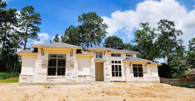 1020 Prescott Dr, Conroe, TX 77301 - prairie-style house featuring stone siding, stucco siding, and roof with shingles