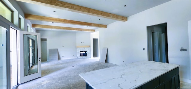 1020 Prescott Dr, Conroe, TX 77301 - unfurnished living room featuring beamed ceiling, a glass covered fireplace, and unfinished concrete flooring