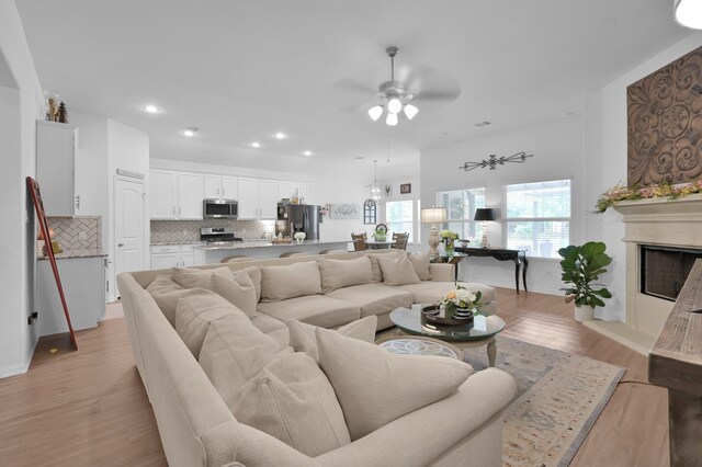 16220 Fayette St, Conroe, TX 77303 - living area with a ceiling fan, recessed lighting, light wood-type flooring, and a fireplace with raised hearth