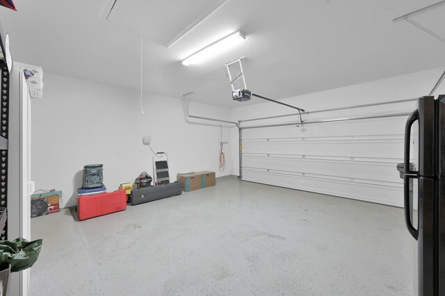 16220 Fayette St, Conroe, TX 77303 - garage with a garage door opener and freestanding refrigerator