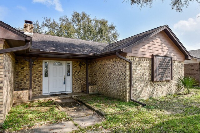 3310 Park Haven Ln, Deer Park, TX 77536 - property entrance featuring a chimney, a shingled roof, and brick siding