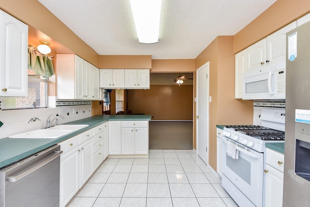 3310 Park Haven Ln, Deer Park, TX 77536 - kitchen featuring stainless steel appliances, tasteful backsplash, white cabinets, light tile patterned floors, and a textured ceiling